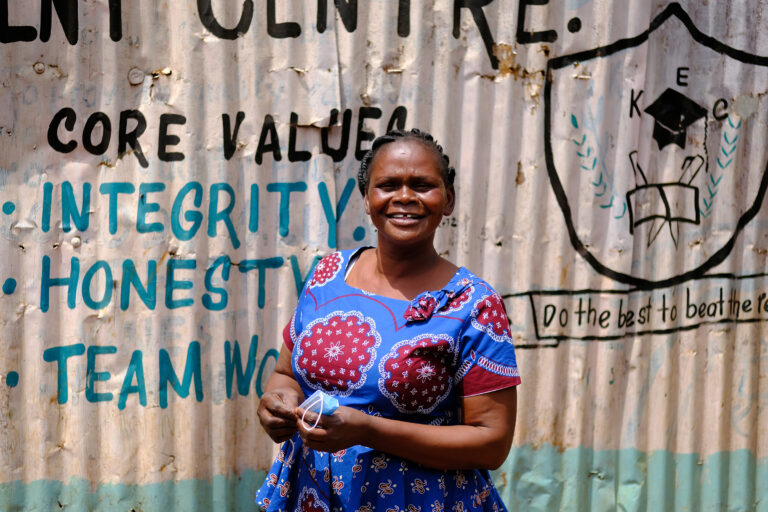 a-woman-standing-in-front-of-a-wall-with-writing-on-it
