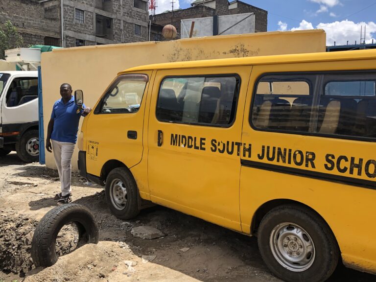 A man leaning against a yellow school bus
