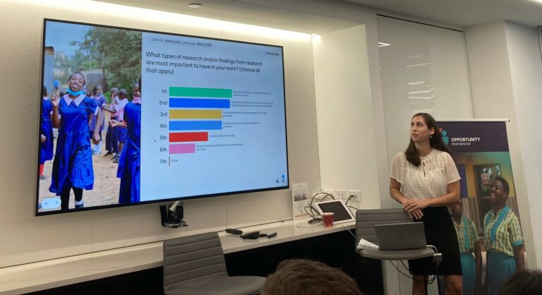 a woman standing next to a screen with a presentation