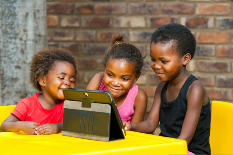 three children engaging with a tablet